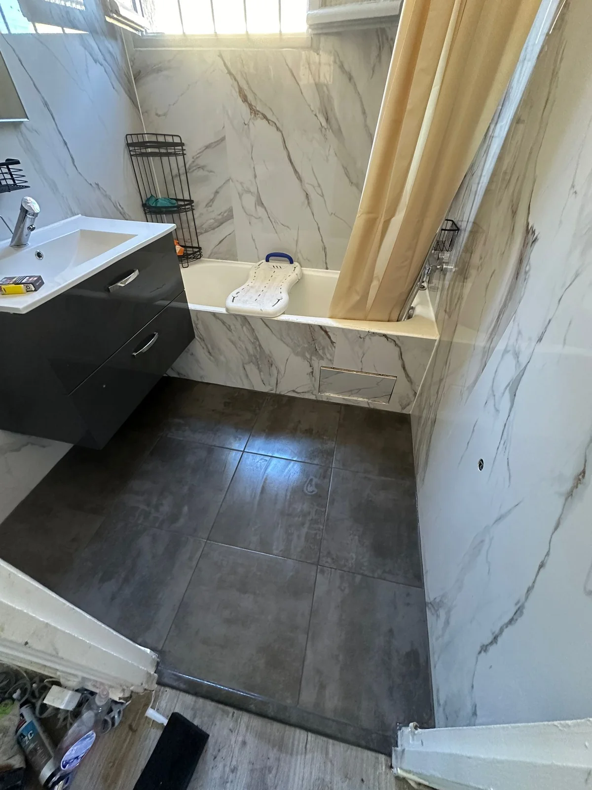 Réalisation Design & Rénovation : salle de bains avec baignoire et revêtement effet marbre